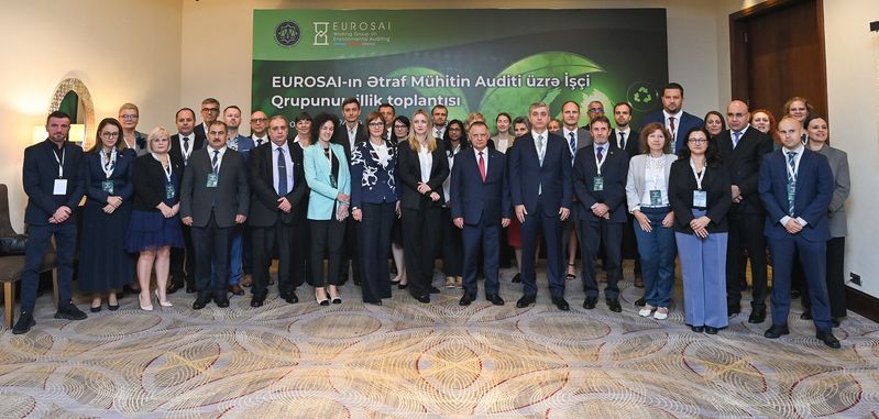 Skupinska fotografija predstavnikov iz različnih vrhovnih revizijskih institucij, ki so se udeležili 22. letnega srečanja delovne skupine EUROSAI za okoljsko revidiranje. Na fotografiji stojijo pred panojem z napisom dogodka in logotipom EUROSAI, dogodek pa je gostila VRI Azerbajdžana in VRI Poljske v Bakuju.
