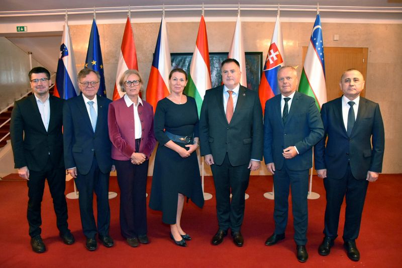 Predsedniki oziroma vodje delegacij sodelujočih VRI Skupinska fotografija udeležencev letnega srečanja vrhovnih revizijskih institucij skupine V4+2 na Bledu septembra 2026. Na fotografiji so predsednica Računskega sodišča Republike Slovenije Jana Ahčin, predsednica VRI Avstrije dr. Margit Kraker, predsednik VRI Češke Miloslav Kala, predsednik VRI Madžarske dr. László Windisch, predsednik VRI Poljske Mariusz Haładyj, predsednik VRI Slovaške Ľubomír Andrassy ter prvi namestnik predsednika VRI Uzbekistana dr. Mehriddin Abdullajev. Stojijo v vrsti pred zastavami sodelujočih držav in Evropske unije.