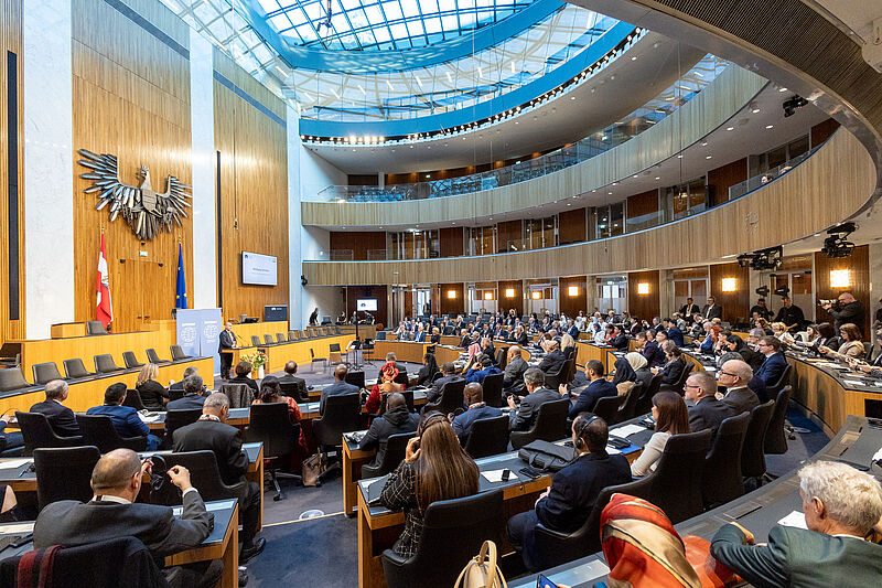 Fotografija dogodka ob obeležitvi 70. obletnice Mednarodne organizacije vrhovnih revizijskih institucij INTOSAI v dvorani Zveznega parlamenta Avstrije na Dunaju, na kateri so vidni udeleženci in govornik predsednik Zveznega parlamenta Avstrije Wolfgang Sobotka