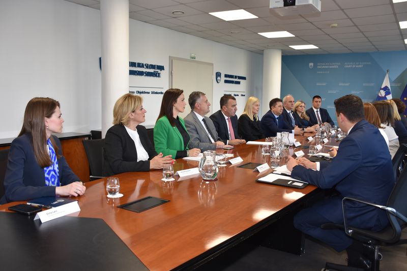 Udeleženci srečanja med predstavniki Računskega sodišča Republike Slovenije in delegacijo Westminstrske fundacije za demokracijo iz Bosne in Hercegovine, zbrani za konferenčno mizo v sejni sobi.