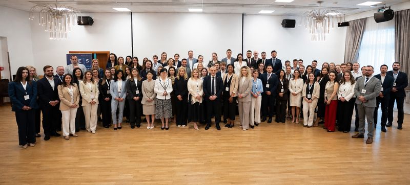 Skupinska fotografija udeležencev Skupinska fotografija več kot šestdesetih udeležencev konference Young EUROSAI. Mladi revizorji in predstavniki vrhovnih revizijskih institucij iz različnih evropskih držav stojijo v več vrstah v svetli konferenčni dvorani in gledajo proti fotografu.