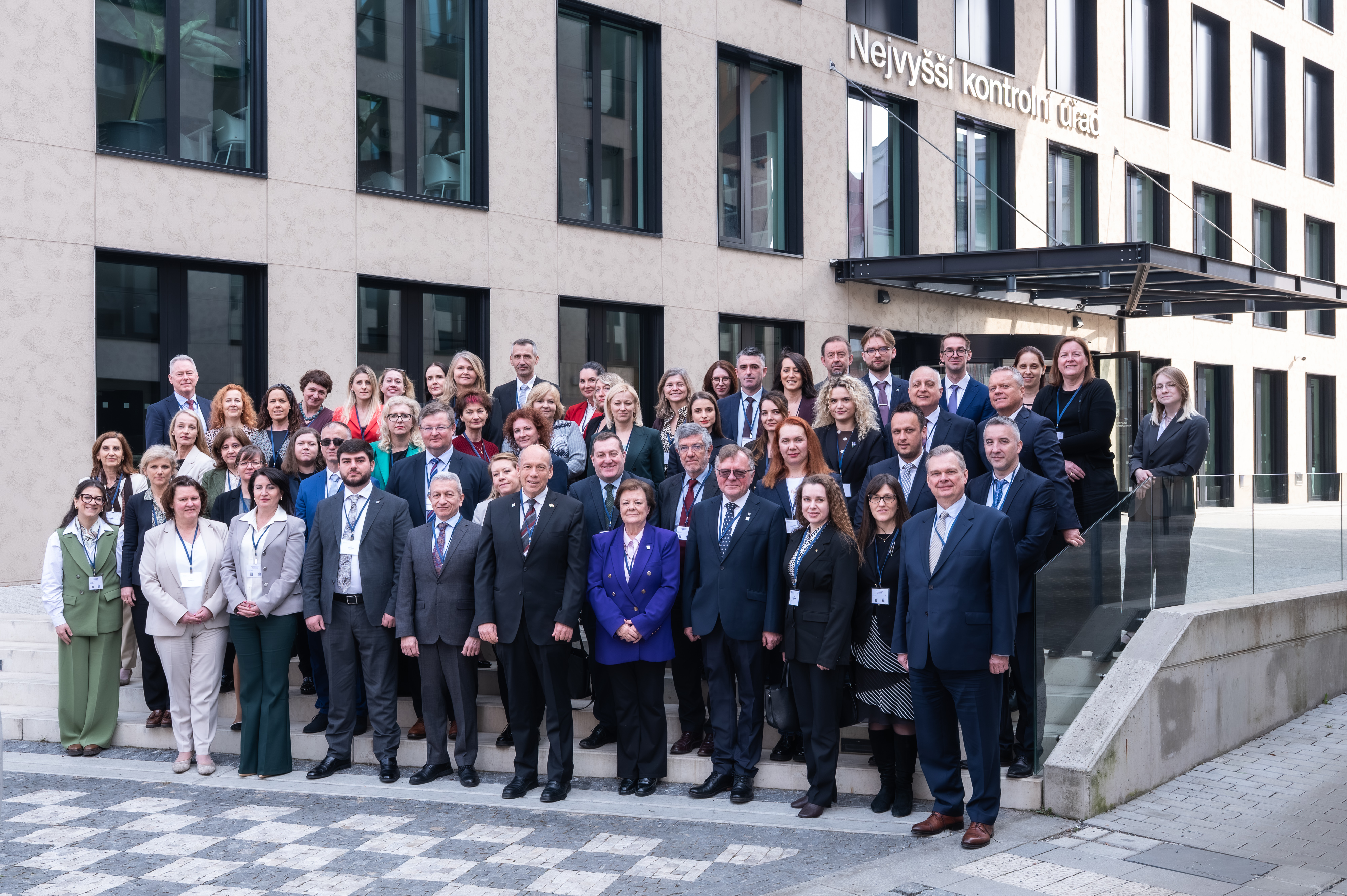 Skupinska fotografija udeležencev v Pragi, stojijo pred vhodom v sedež vrhovne revizijske institucije Češke republike