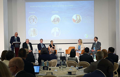 Generalni revizor Malte Charles Deguara nagovarja udeležence ob odprtju skupščine INTOSAI WGEA; ob njem sedijo osrednji govorci in panelisti prve razprave